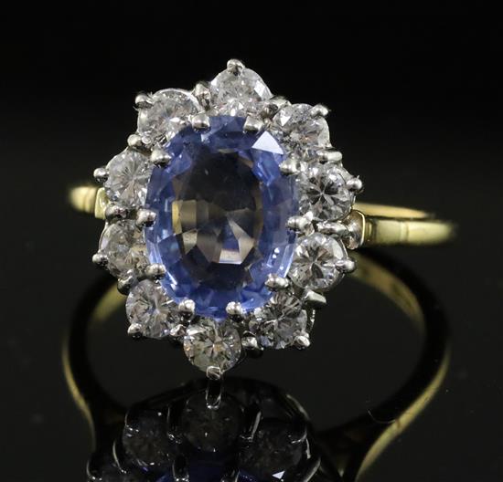 A modern 18ct gold, sapphire and diamond oval cluster ring, size O.